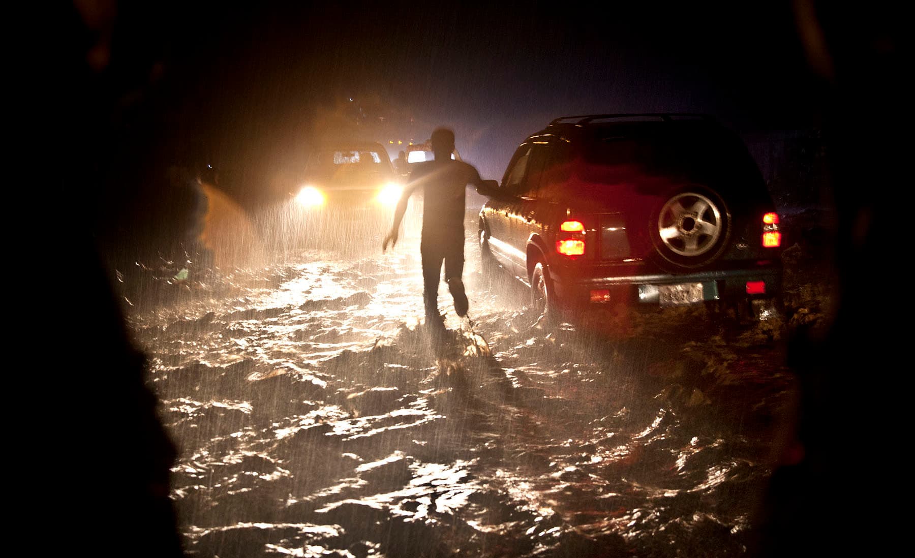 A man running through a street flooded with water