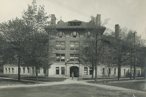 Black and white photo of a tall brick building.