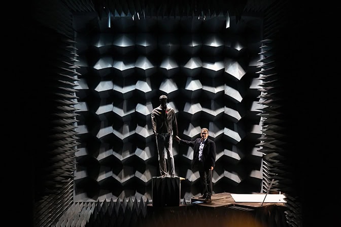 a full shot image of sarabandi standing next to the test mannequin in the anechoic chamber