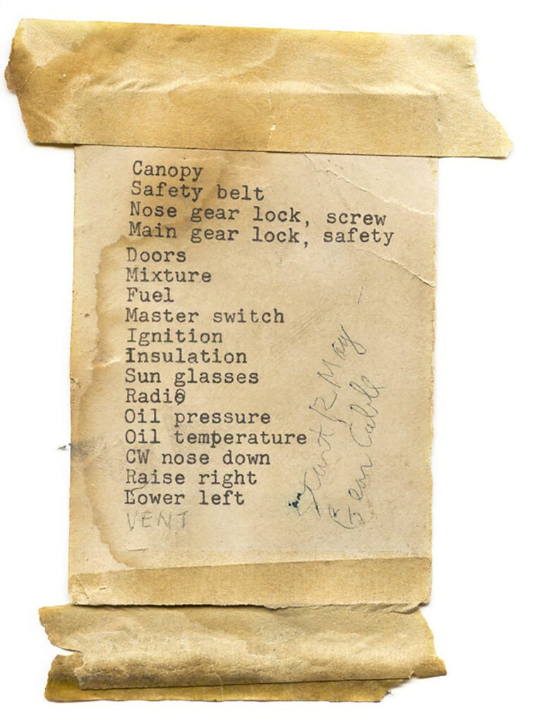 Photo of an old, typewriter-printed list with items such as "Canopy, Safety Belts, Nose gear lock, Main gear lock," and old masking tape is still adhered to the top and bottom of the paper.
