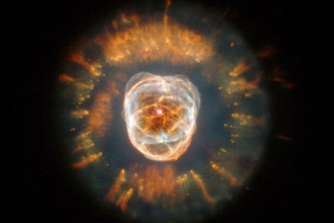 A telescope image of space—black, dotted with hundreds of amber-colored points of light.