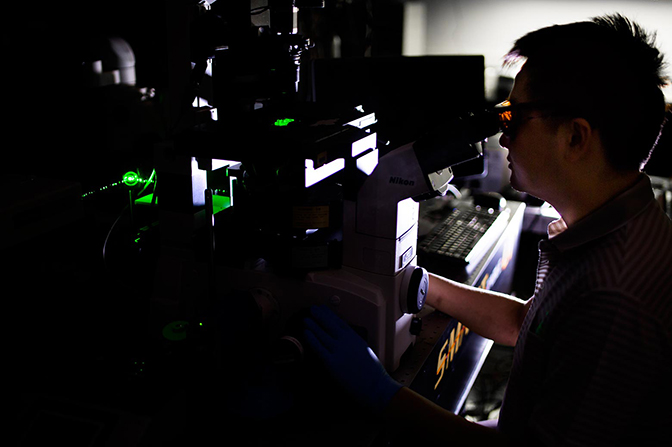 image of yu-chih chen the researcher viewing chip through microscope