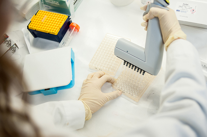 image of researcher working in lab on the microfluidic device