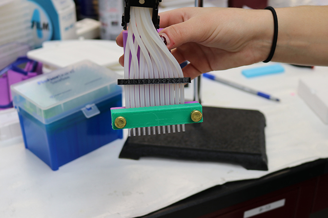 image of researcher holding the microfluidic device