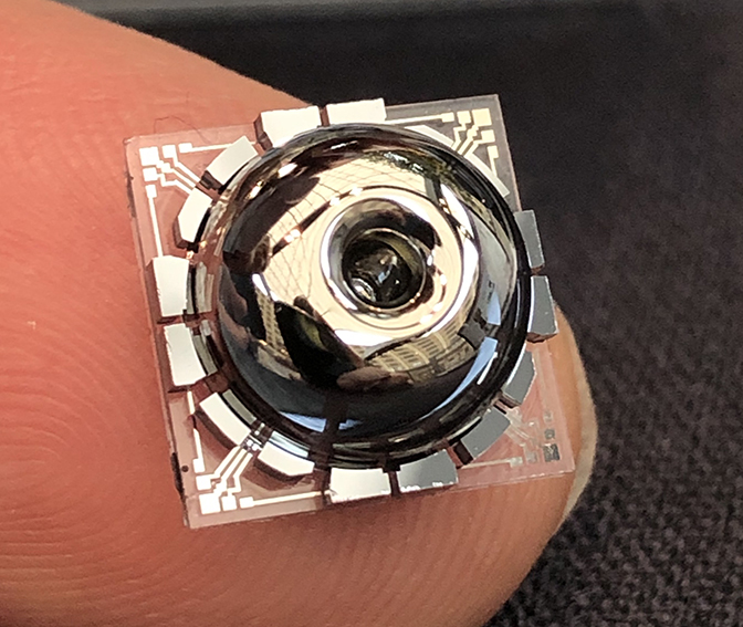 a close up image of the resonator and electrodes placed on top of a finger for scale comparison