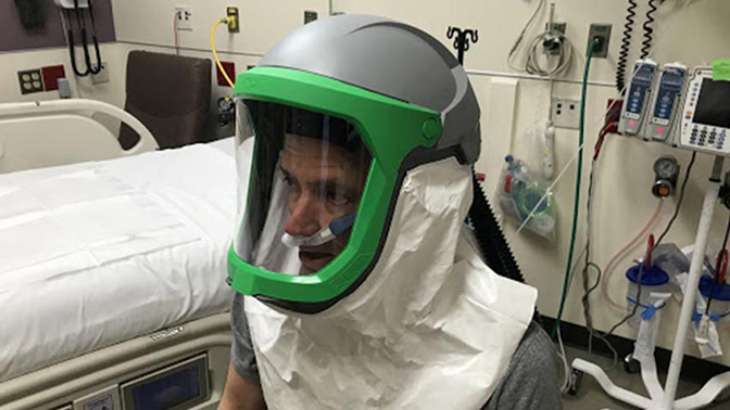 an image of doctor kevin ward testing the negative pressure helmet system to support patients and protect health care workers