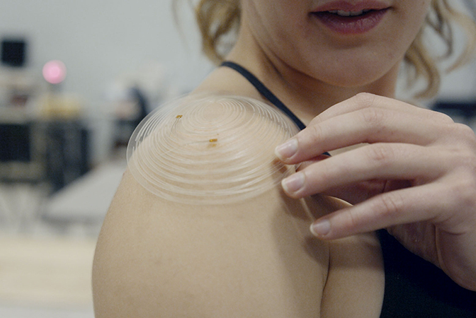 image of erin evke demonstrating how the kirigami sensor follows the curves of her shoulder and be attached