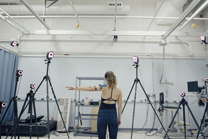 full shot image of erin evke demonstrating how the motion capture camera and kirigami sensor pick up her movements