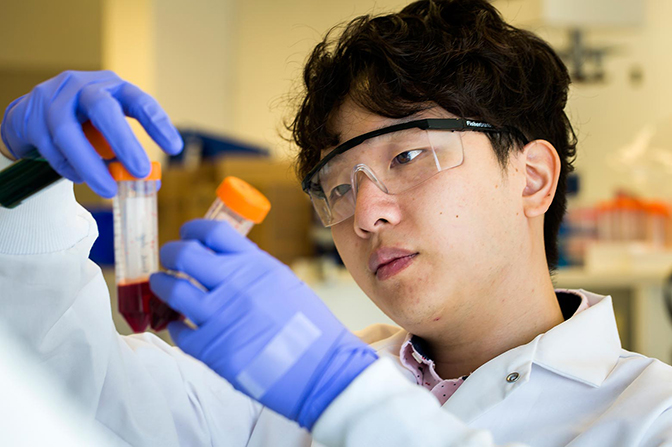 image of eric lin holding blood samples to prepare to run the samples on labyrinth chip