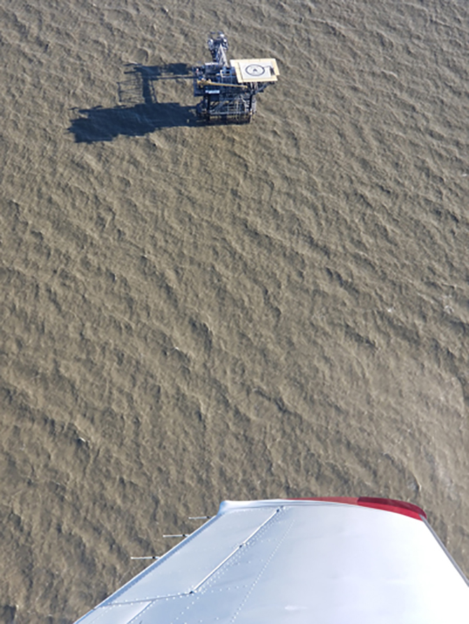 an image of an oil rig at gulf of mexico viewed from plane up above