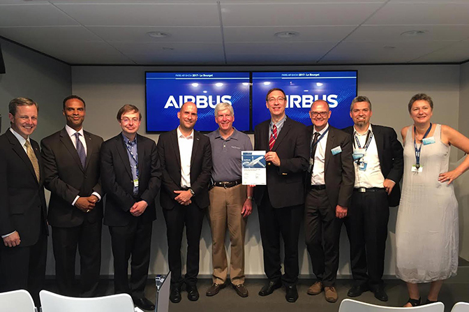 a group photo of the representatives from u of m and airbus marking the start of their partnership with a signing