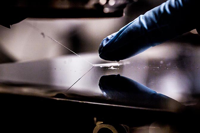 Close up of researcher's glove touching polymeric material