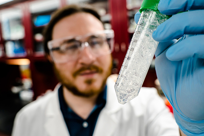 a close up image of jeremy minty, the president of ecovia renewables, holding up a sample of the company's azuragel product after absorbing water