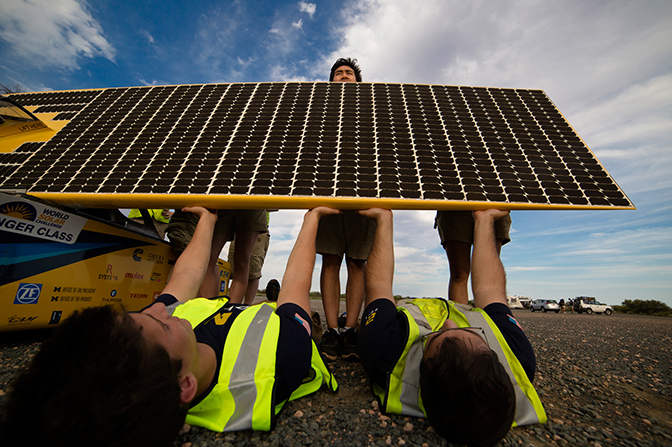 Solar Car Team helping hold the solar car Novum;s gallium arsenide solar cells during a change to the car’s charging configuration.