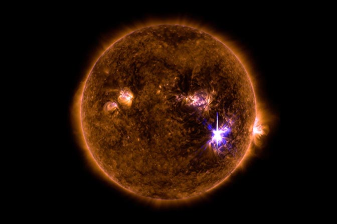 Solar flare coming off of sun against a stark black background