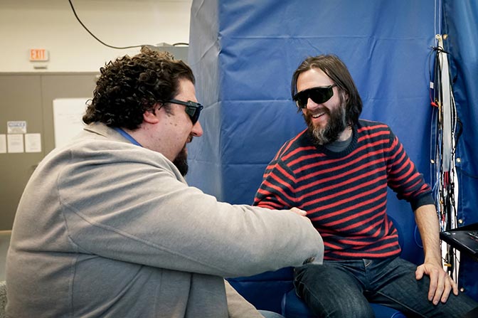 Researchers in lab shaking hands