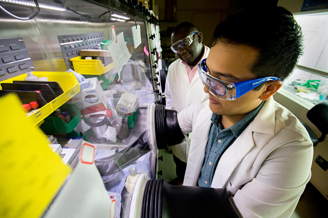 an image of materials science and engineering phd student alan olvera and professor Pierre Ferdinand Poudeu-Poudeu sealing off glass vacuum tubes during the process of constructing a stable copper selenide material