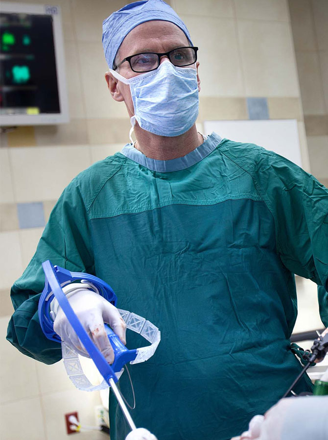 surgeon in scrubs holds flexdex device