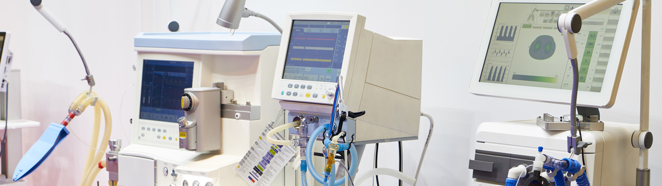 Several monitors and medical devices in a white room.