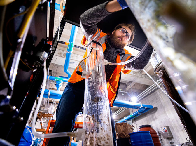 Student leans over tubes transporting water