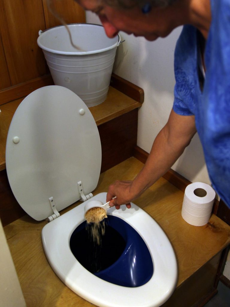 A person pouring oats in a toilet