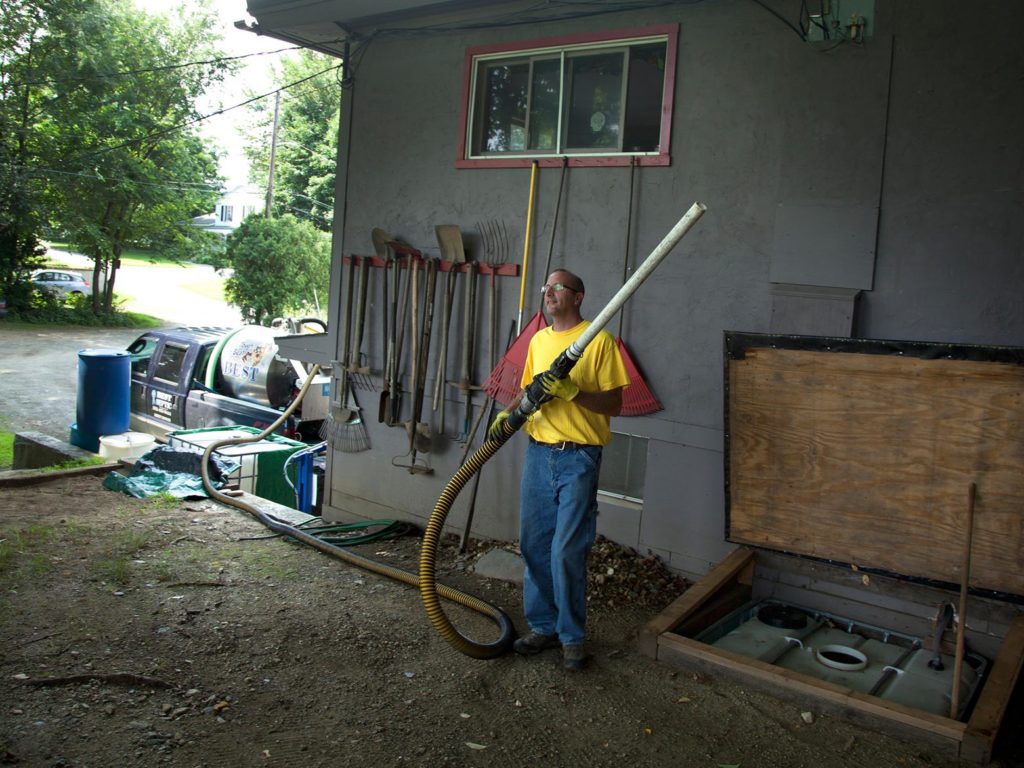 A man standing with an industrial hose