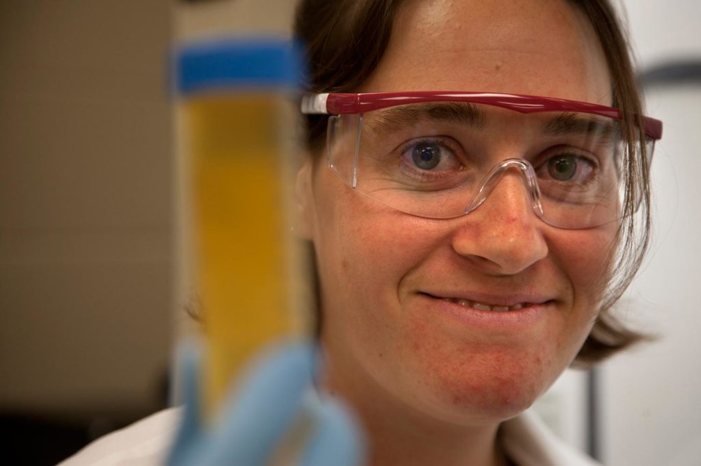 a person holding up a urine sample