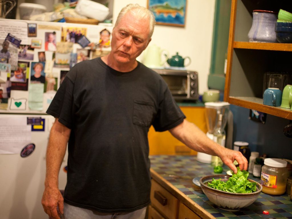 person standing with a bowl of lettucre