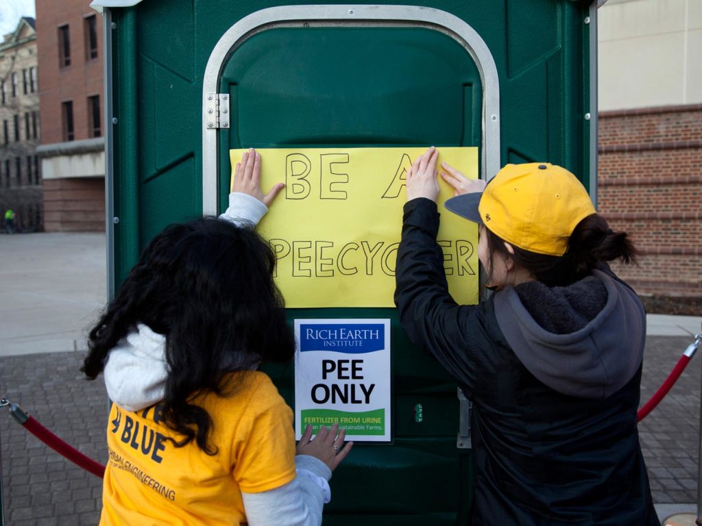 putting up a sign on a portable toilet