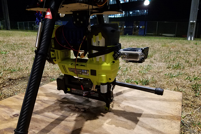 A machine placed on a small wooden plank outdoors.