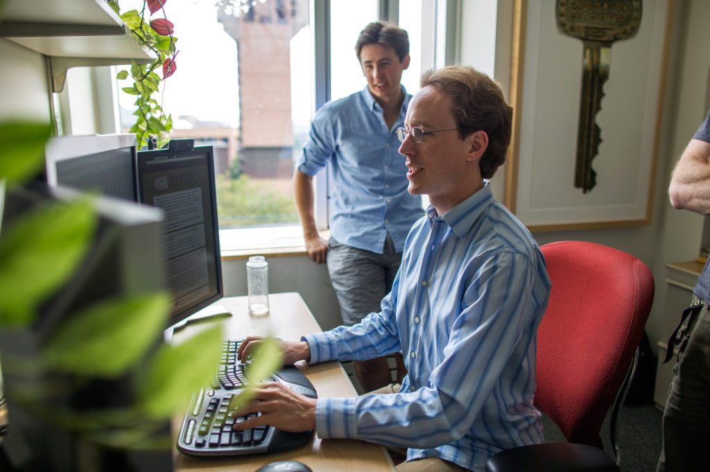 an image of censys cto zakir durumeric and chief scientist alex halderman looking at their internet-wide scanning tool on computer screen in an office