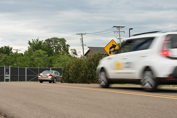 A car speeds towards a second car stopped far in front of it.