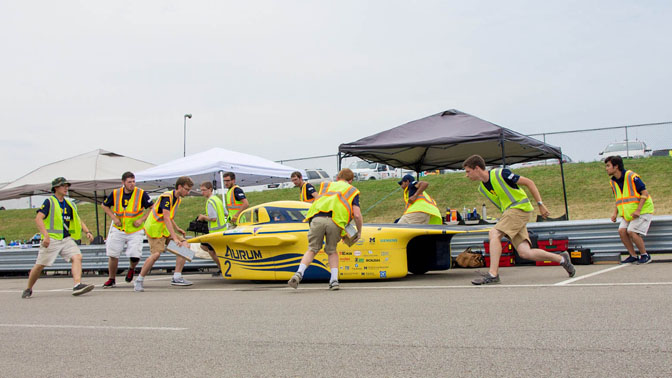 Solar car team performing pit stop.