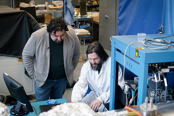 Two men looking over a workbench in a lab