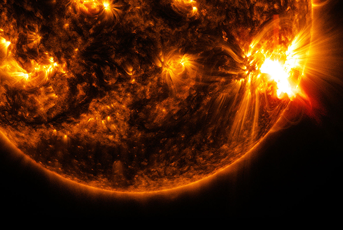 an image of an x2.0-class solar flare bursting off the lower right side of the sun captured by the nasa's solar dynamics observatory