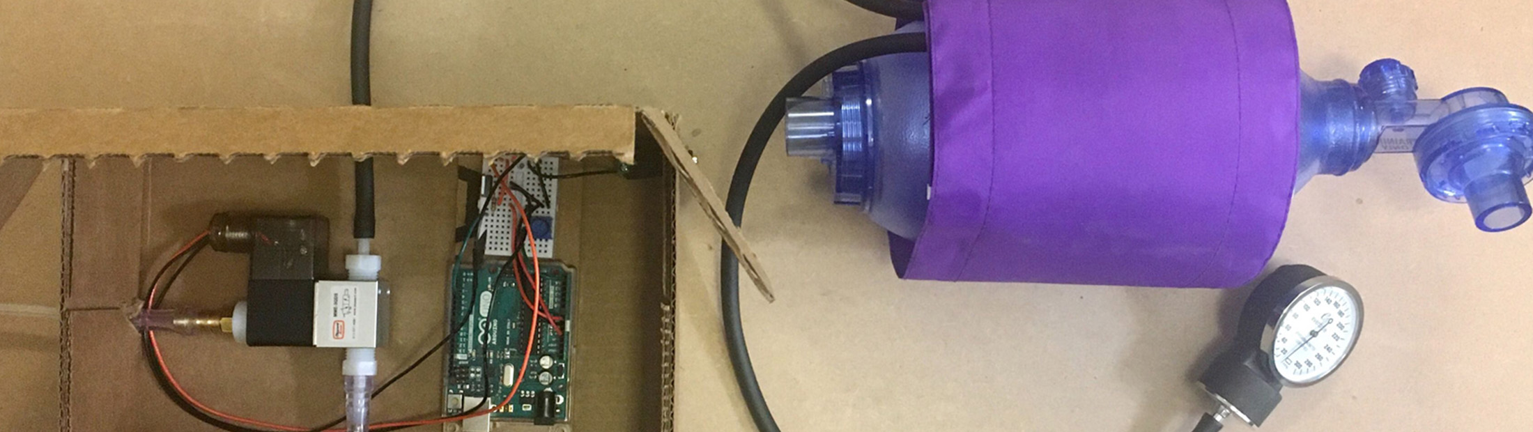 Makeshift ventilator prototype consisting of simple brown cardboard box and pump