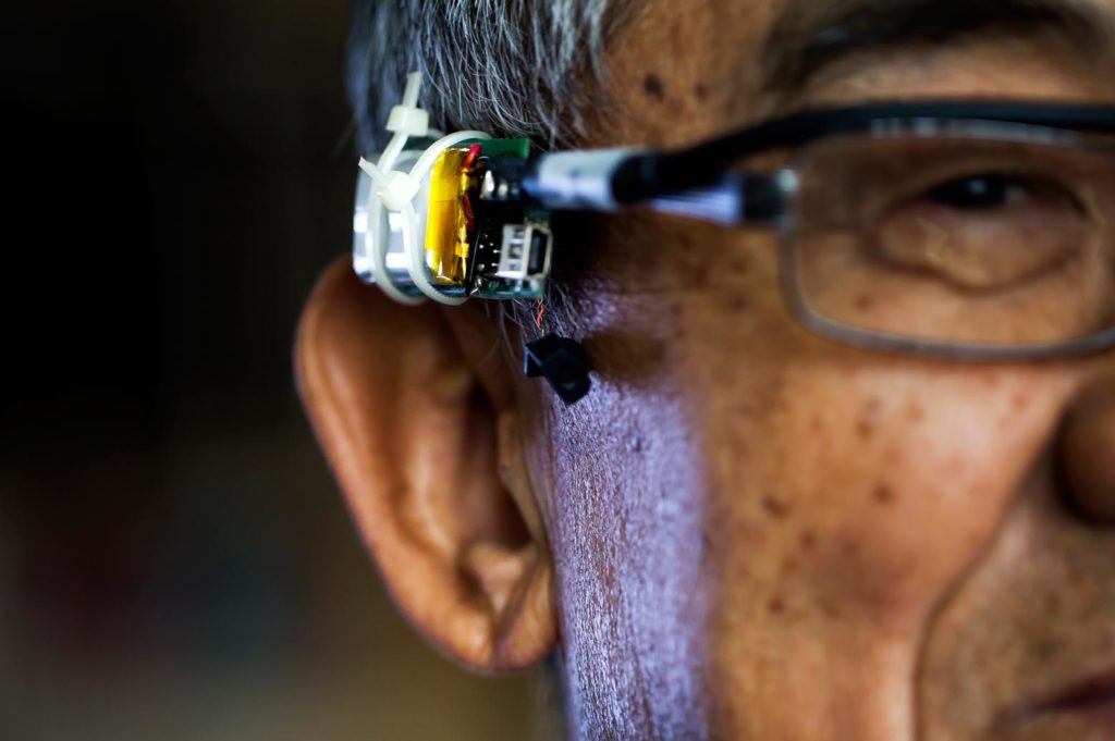 Close up of Professor Shin demonstrating the wearable voice authentication device on his glasses