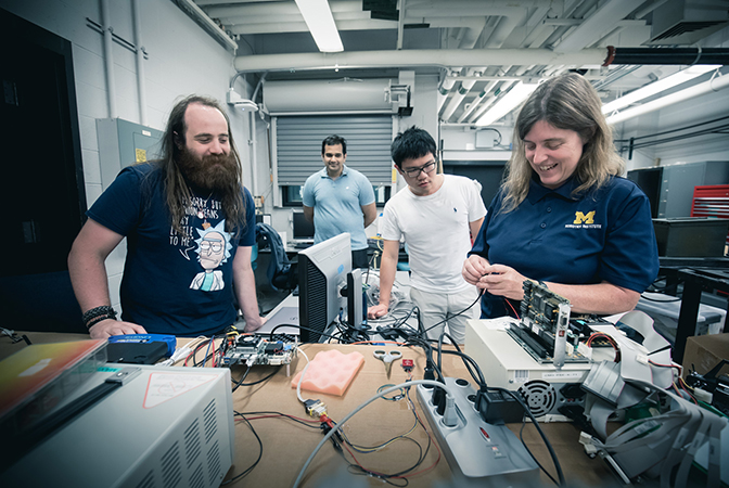 Image of Atkins and researchers working in Carlos Cesnik's lab.