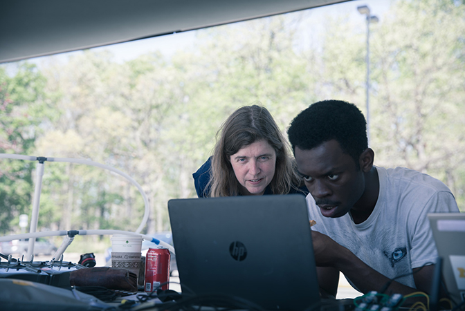 Image of Atkins and Prince Kuevor evaluating software settings for an autonomous aerial vehicle test