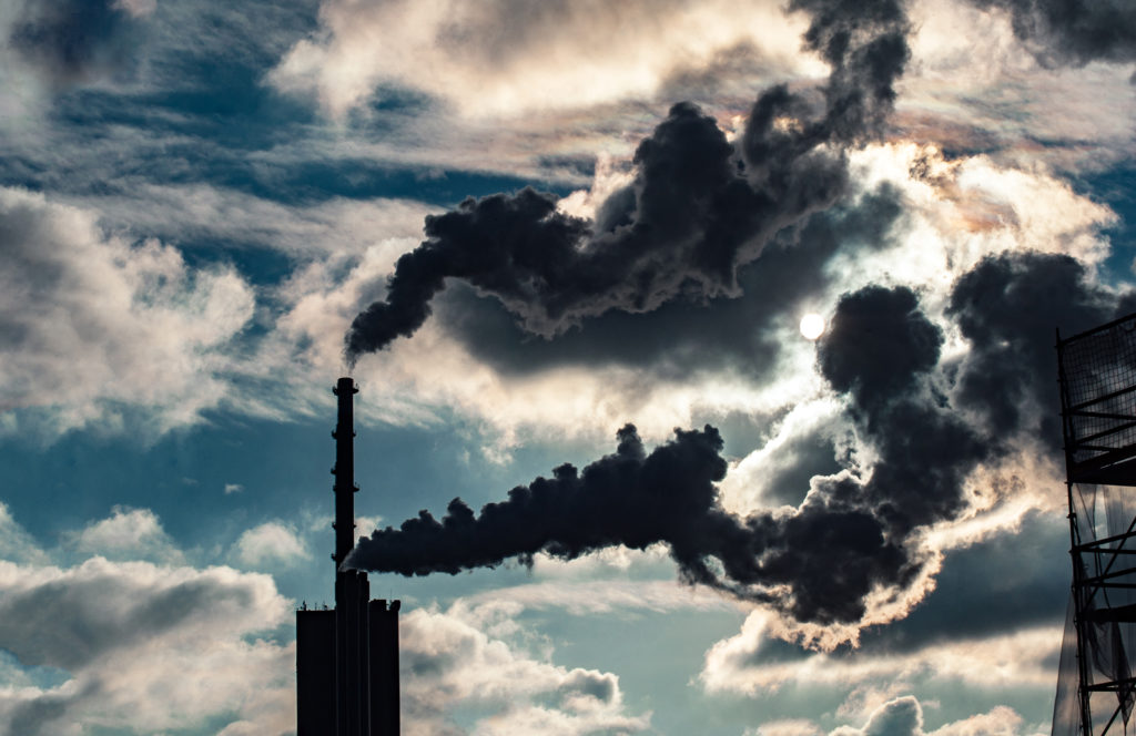 A smoke stack emitting large plumes of smoke.