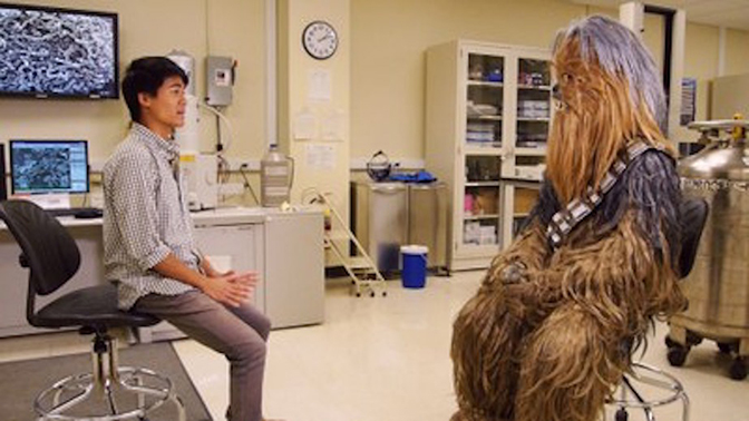 Chewie and a man sitting across from each other in chairs.