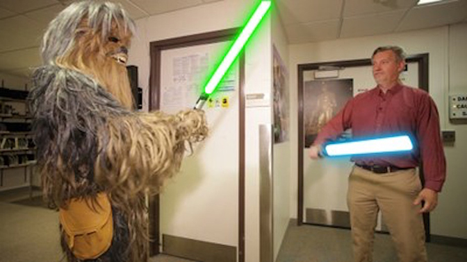 Chewie and Professor Karl Krushelnick holding light sabers.