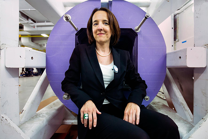 A portrait of Sara Pozzi sitting nex to a newly installed linear accelerator in the U-M Nuclear Engineering Lab.