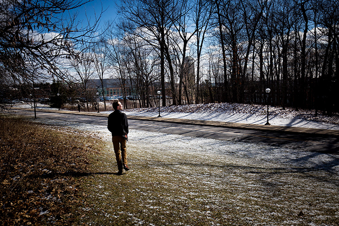 A man standing outdoors among snow and trees.