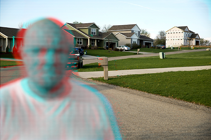 A glitch-like image of a man in a neighborhood with houses