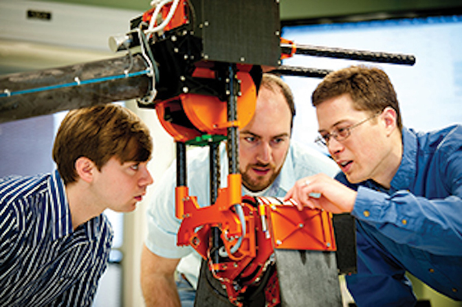 Three men looking closely at a machine.