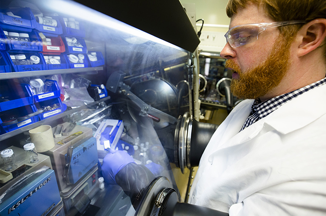an image of nathan taylor inspecting a piece of lithium metal at a lab