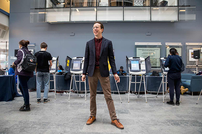 full shot image of professor halderman standing while students participate in a mock election