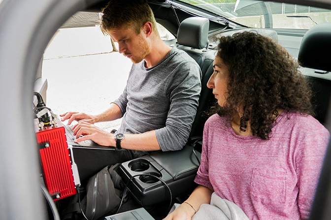 Image of Necmiye Ozay and Lars Petter Nilsson testing their software at Mcity inside a car.