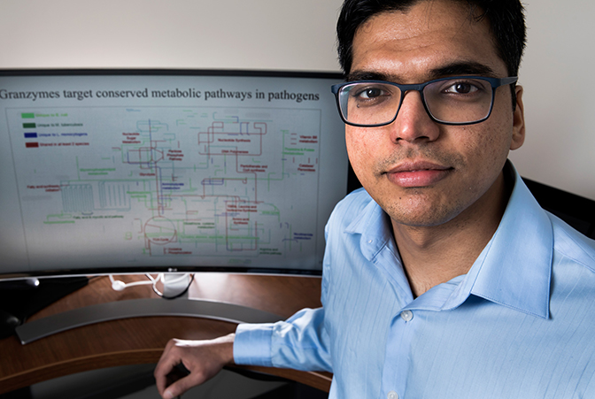 A portrait shot of Sriram Chandrasekaran with his research on screen